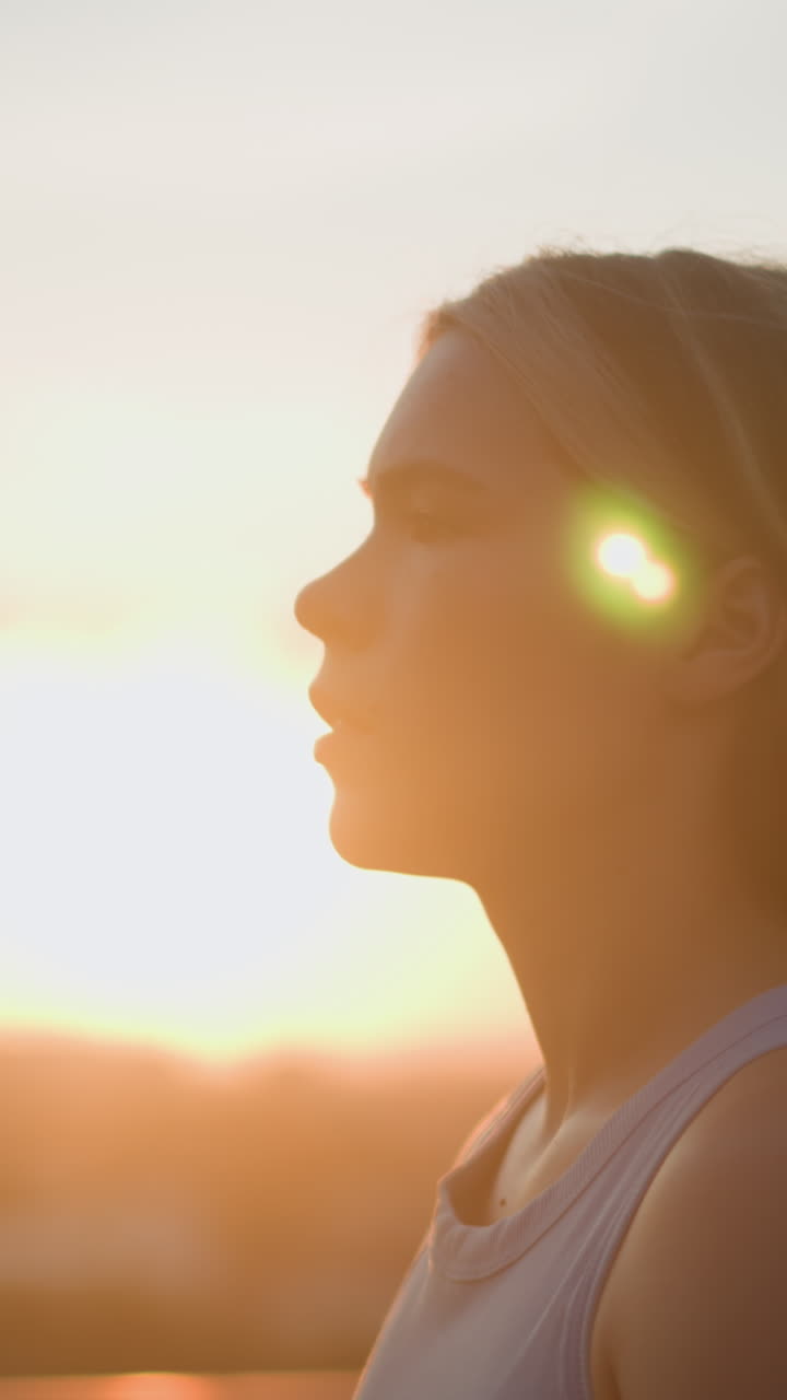 vista lateral de una joven caminando al aire libre con expresión enfocada, luz esmeralda reflejándose en su cabello bajo la cálida luz del sol, creando un efecto de silueta contra un fondo suave