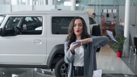 beautiful young woman scattering money in a car dealership