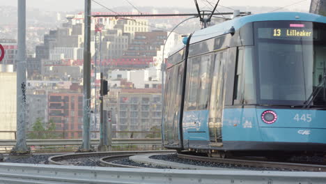 a modern tram descends kongsveien in front of bjorvika, central oslo