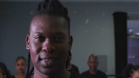 Portrait-of-a-mixed-race-modern-male-dancer-looking-at-the-camera