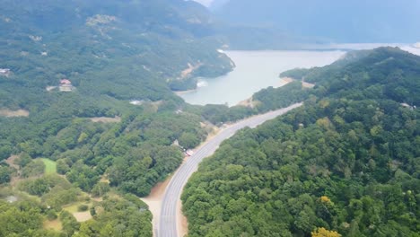 vista aérea de una carretera sinuosa a través del bosque y el lago