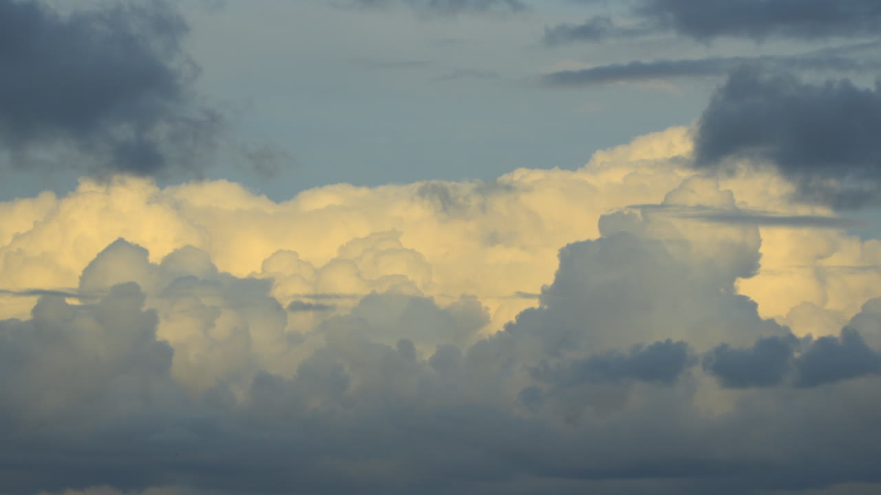 nubes cumulonimbus de varios tonos a medida que las sombras avanzan en el fondo durante la hora dorada