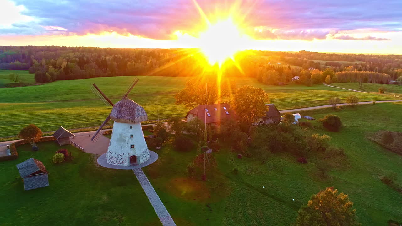 Aerial view showing Āraiši Windmill in idyllic countryside landscape during sunset time in Latvia