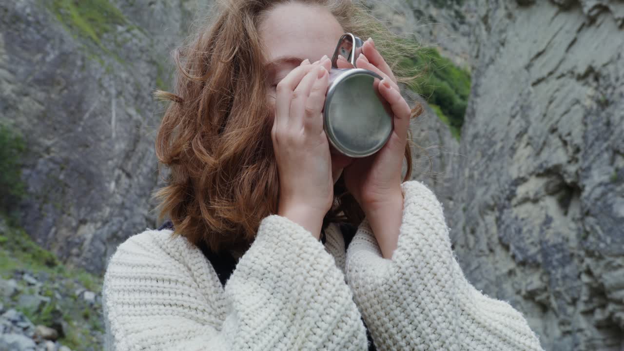 una adolescente disfrutando de una copa en las montañas