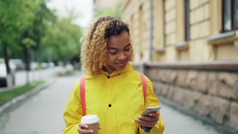 young woman walking down city street in rain