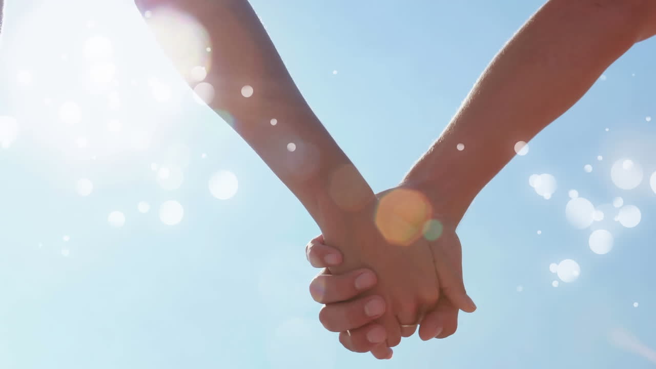 보케 효과로 둘러싸인 손을 잡은 커플