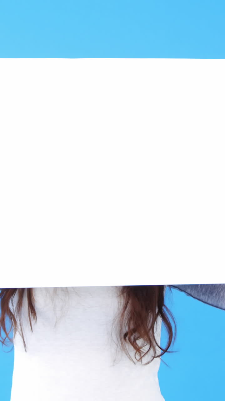 hermosa mujer sosteniendo un cartel en blanco sobre un fondo azul