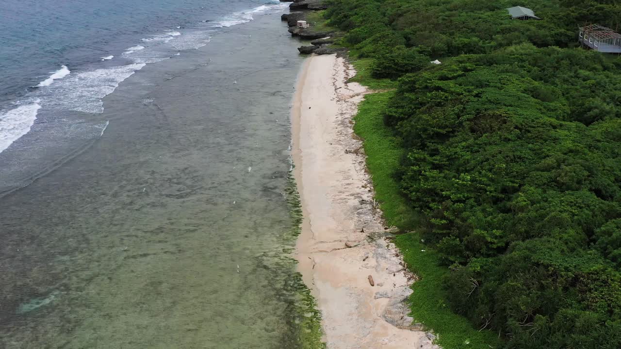 dolly drone aéreo en tiro, costa con olas oceánicas golpeando la costa rocosa y la hermosa playa en la isla xiaoliuqiu lambai, condado de pingtung, taiwán