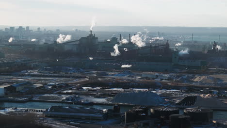 industrial landscape with smokestacks against a city backdrop, highlighting environmental impact