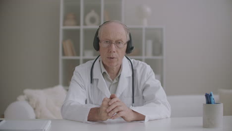 aged professor of medicine is lecturing online from his office in clinic medium portrait of doctor