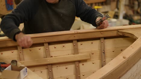 hammering copper nails securing covering boat wooden boat built