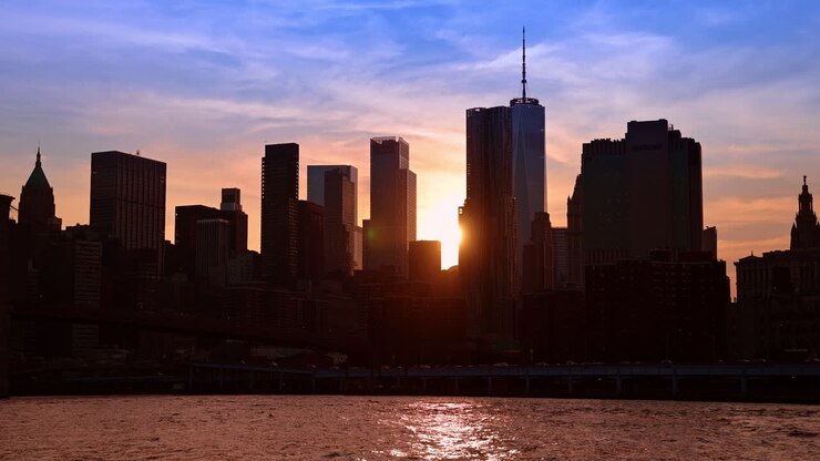 New York, USA, 8 agosto 2025: skyline al tramonto di Lower Manhattan. I grattacieli di Lower Manhattan formano silhouette scure sullo sfondo di un cielo colorato al tramonto