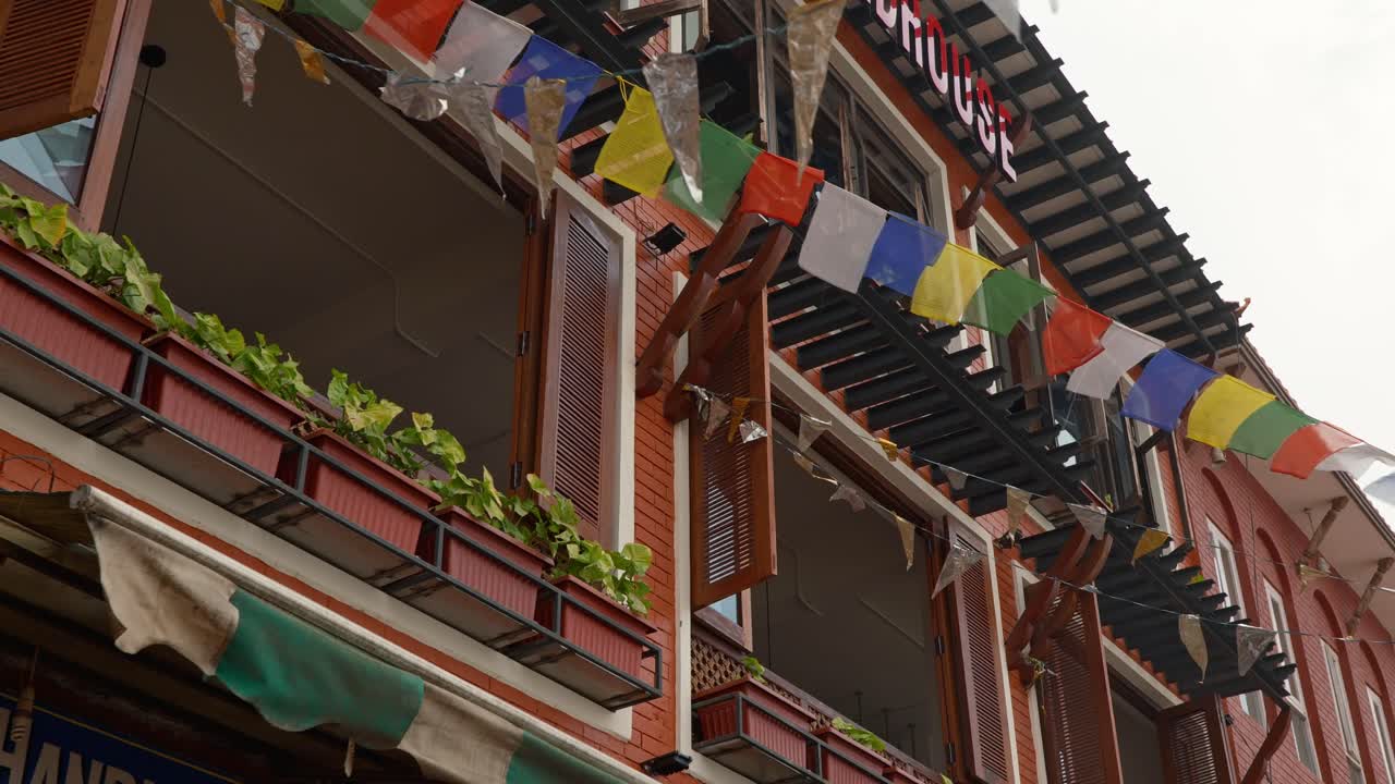 Building in Kathmandu with tibetan flags waving outside the open windows. (high-Res)
