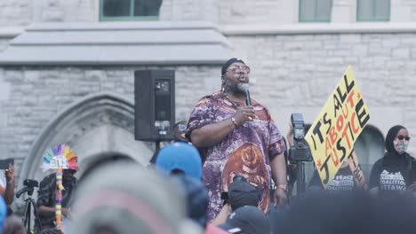black leader speaking in front of a black lives matter protest in ottawa, ontario