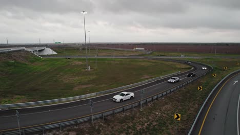 AERIAL---Cars-on-highway,-cloudy-day,-Reynosa,-Tamaulipas,-Mexico,-reverse-rising