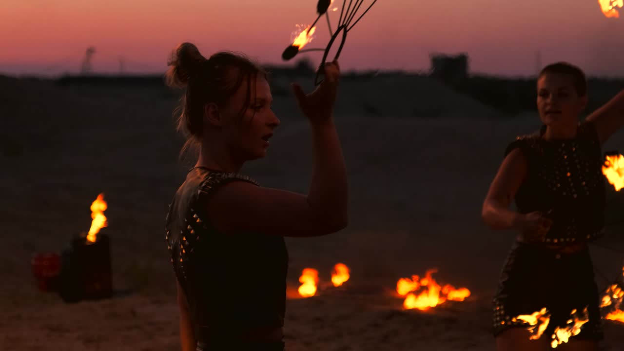 Bailarinas profesionales realizan un espectáculo de fuego y una actuación pirotécnica en el festival con antorchas encendidas y chispeantes.