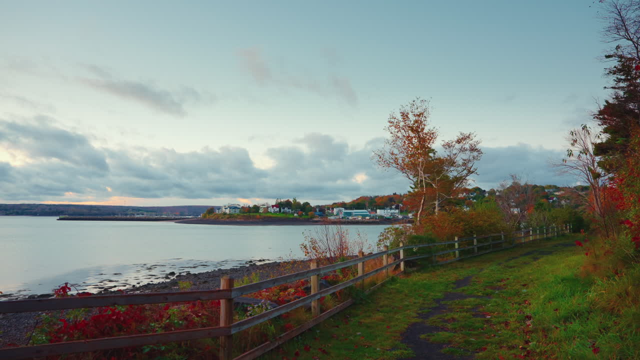 Canadian landscape at the seaside. View of the coastline and the warm autumn colors of the trees leaves. Yellow-orange hues.