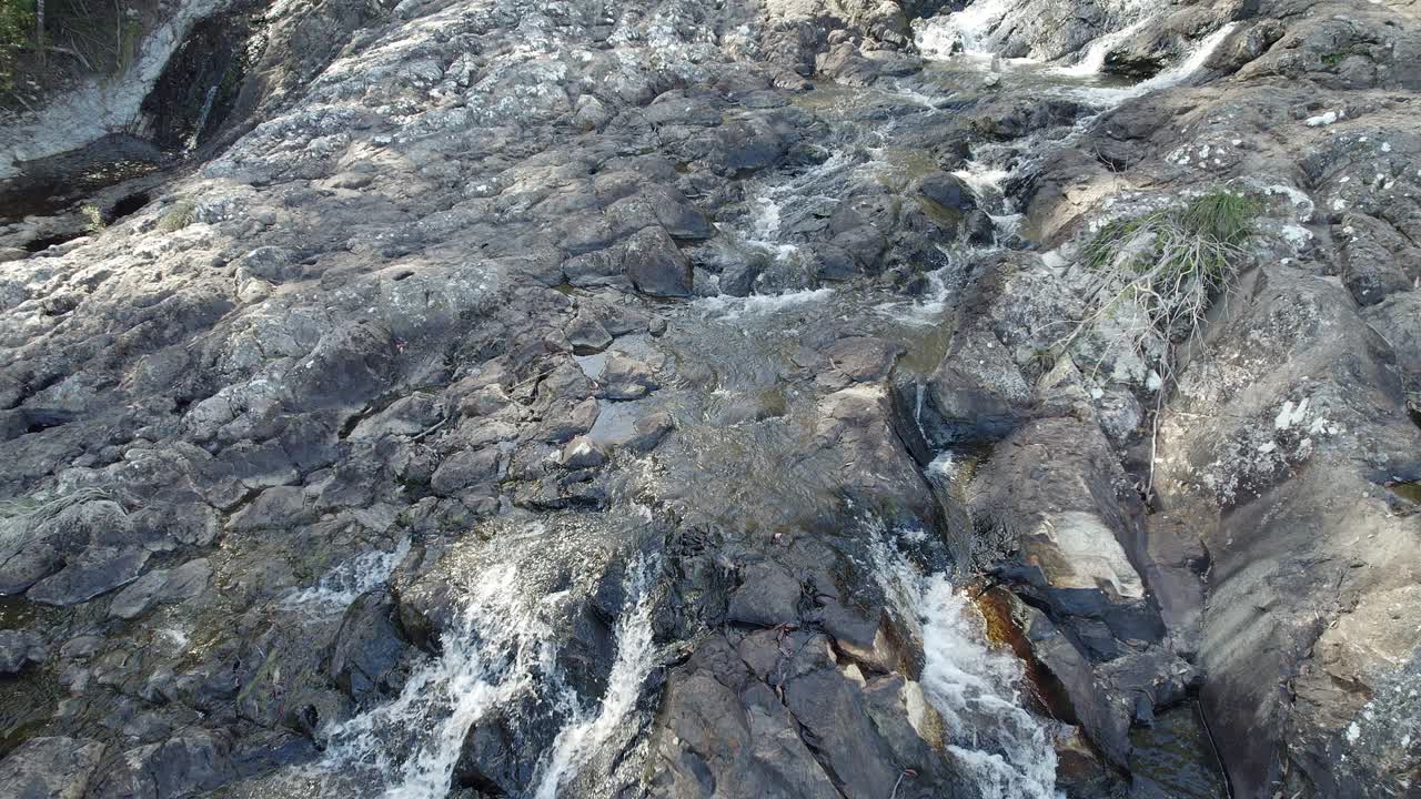 minyon falls - arroyo que fluye sobre rocas hacia un acantilado escarpado en la región de los ríos del norte, australia
