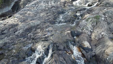 Minyon-Falls---Arroyo-Que-Fluye-Sobre-Rocas-Hacia-Un-Acantilado-Escarpado-En-La-Región-De-Los-Ríos-Del-Norte,-Australia