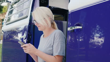 woman texting in retro camper van