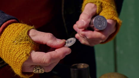 examinando una moneda recién acuñada hecha de un punzón de moneda vikingo vintage - aislado
