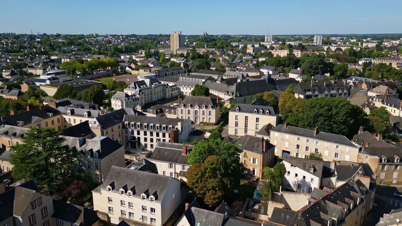Wide aerial ascend over Laval city showing rooftops, river, green lscape, sunny day