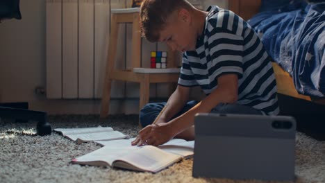 niño haciendo la tarea en el suelo