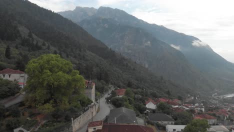 aerial view of traditional greek village high at mountains forest around red roofs typical stoned houses travel lifestyle