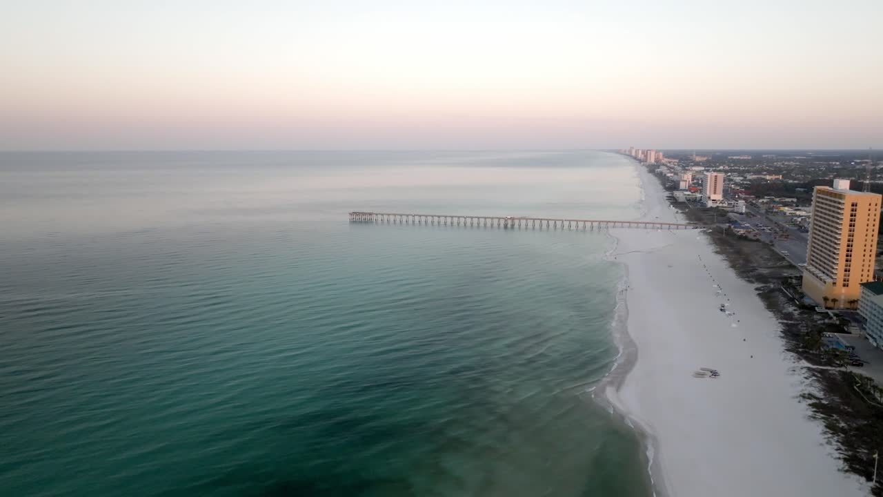 Pier in the Gulf of America in Panama City Beach, Florida with drone video moving in.