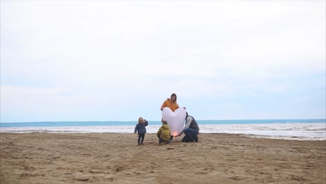 family launching a heart-shaped sky lantern on the beach