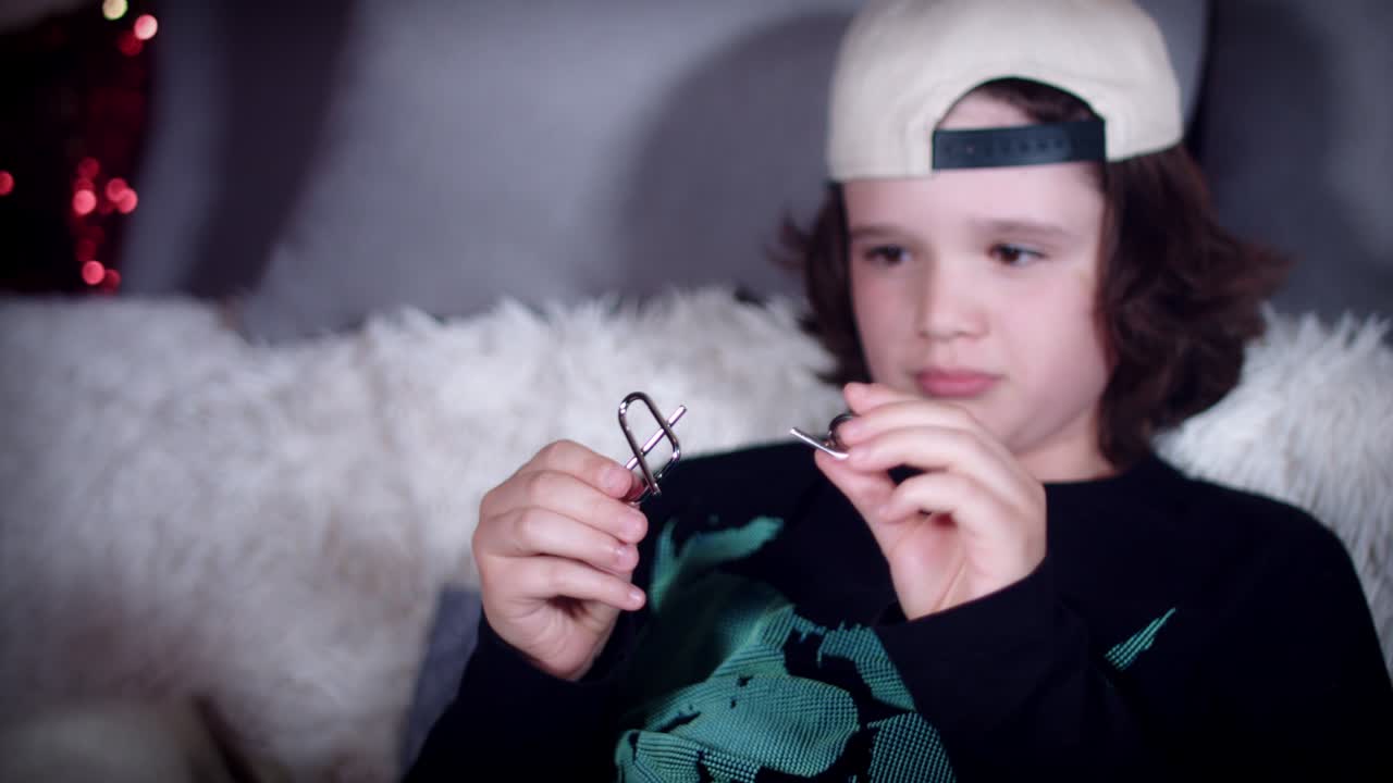 4k de manos de niños jugando con rompecabezas de metal para el cerebro teaser