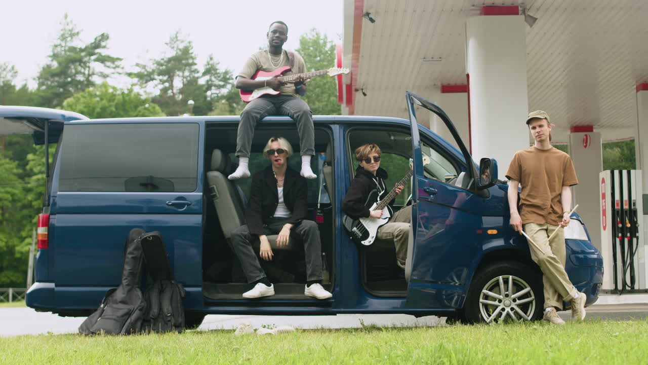 밴드가 주유소에 있는 밴에서 포즈를 취하고 있다