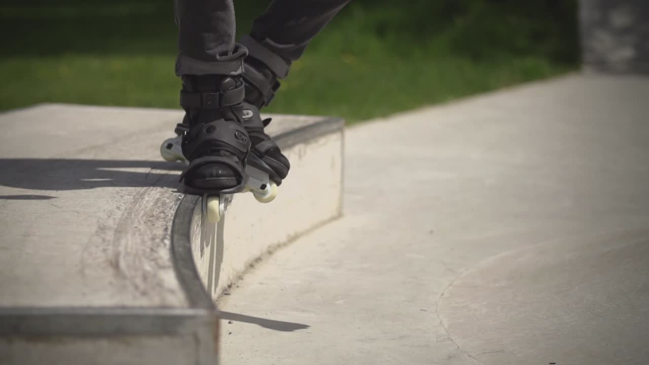 Rallentatore di un ragazzo che esegue una manovra con i rollerblade, ripreso in uno skate park