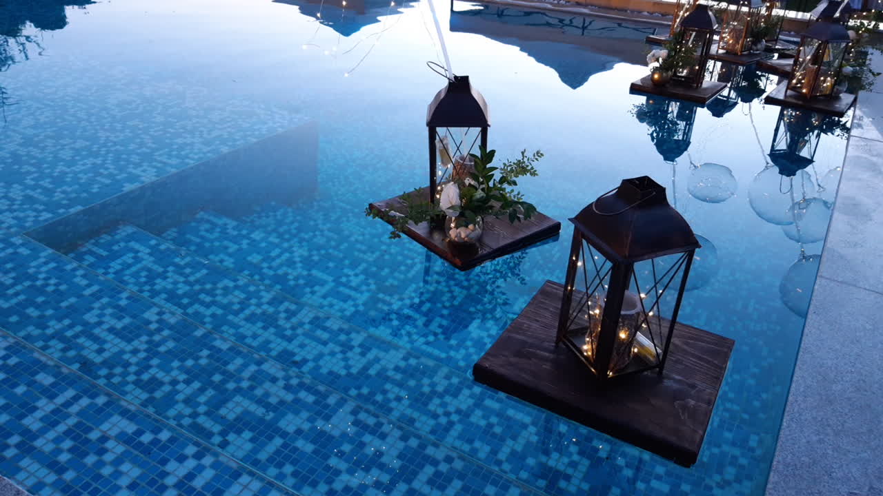 decoración de la piscina con una vela romántica y un jarrón de flores flotando en la superficie del agua