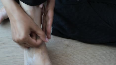 woman applying lotion to her feet