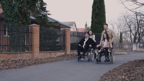 woman and man running with her disabled friends in wheelchair and having fun together