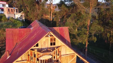 "es una toma de un dron moviéndose hacia una cabaña de madera al amanecer