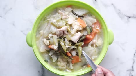 chicken vegetable soup in a green bowl