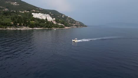 A drone captures a picturesque seashore as a speedboat slices through the water, heading toward the shore, creating a stunning and dynamic coastal scene.