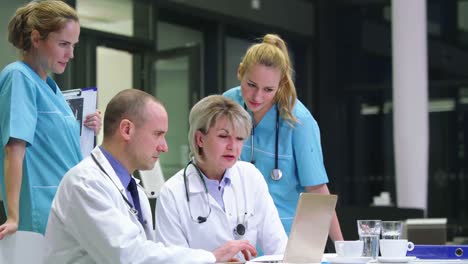 Ärzte-Und-Krankenschwester-Diskutieren-Am-Laptop-Im-Konferenzraum