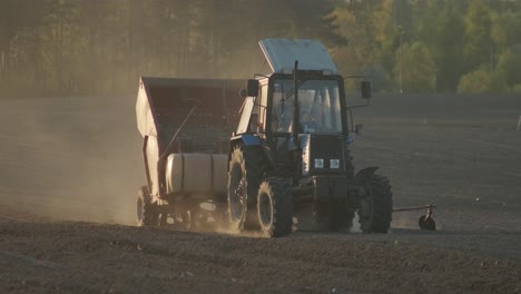 planting a large agricultural field. the tractor pours potatoes into the holes. agricultural work, farming.