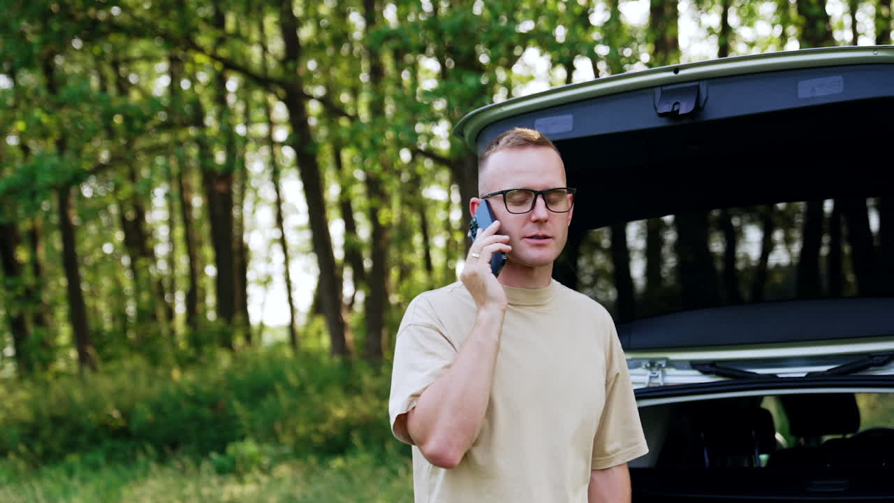 Caucasian man in glasses and beige t-shirt having phone conversation. Connection breaks and man is unhappy.
