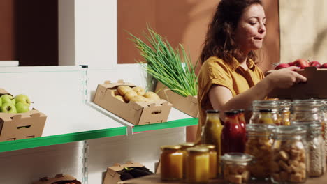mujer añadiendo manzanas de la tienda ecológica a la cesta