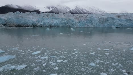 Un-Glaciar-Y-Una-Montaña-Circundante-Reflejándose-En-El-Agua-Helada-Del-Mar-ártico.