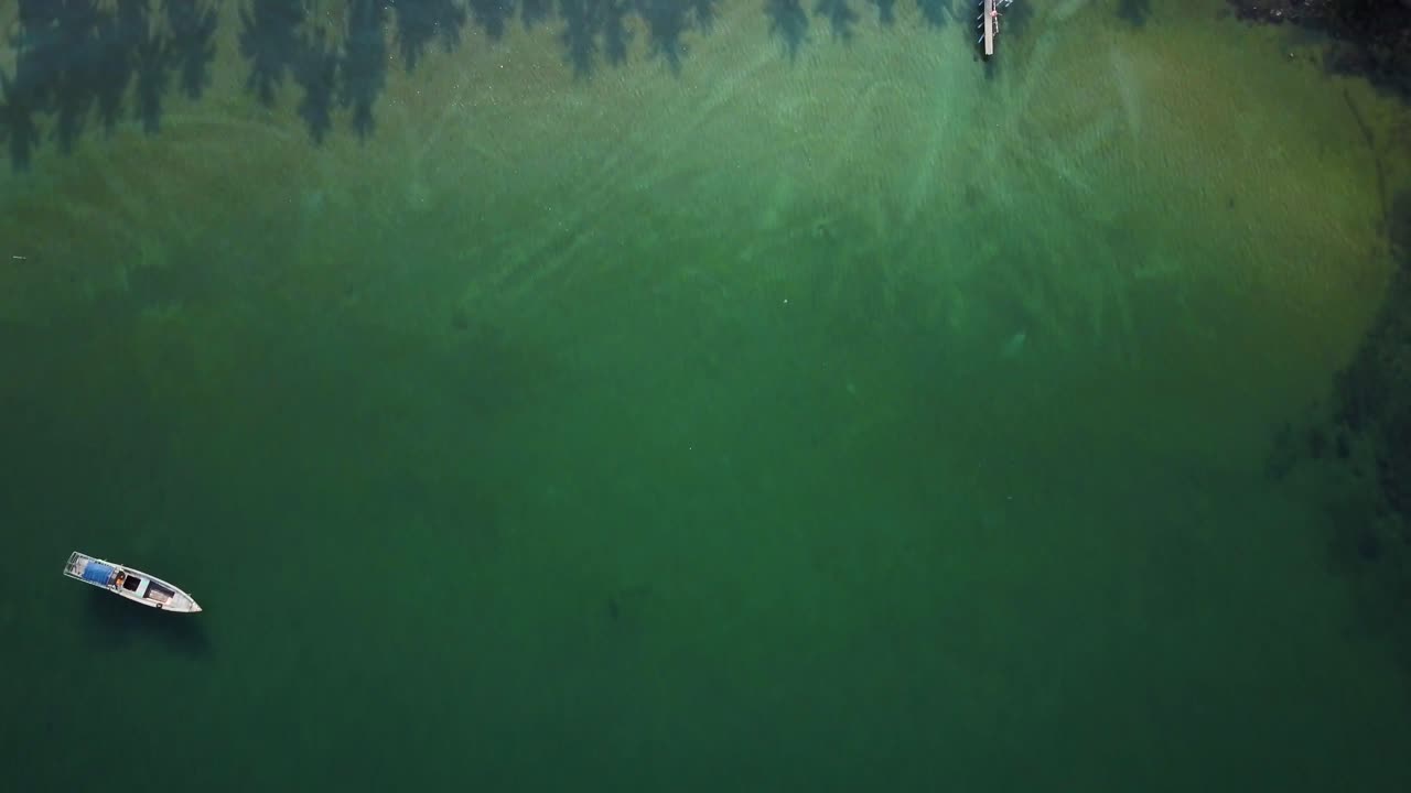 Aerial view of a tropical beach with boat and pier