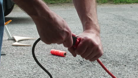 hombre desconectando la herramienta eléctrica del cable de extensión afuera, cerrar, cámara lenta