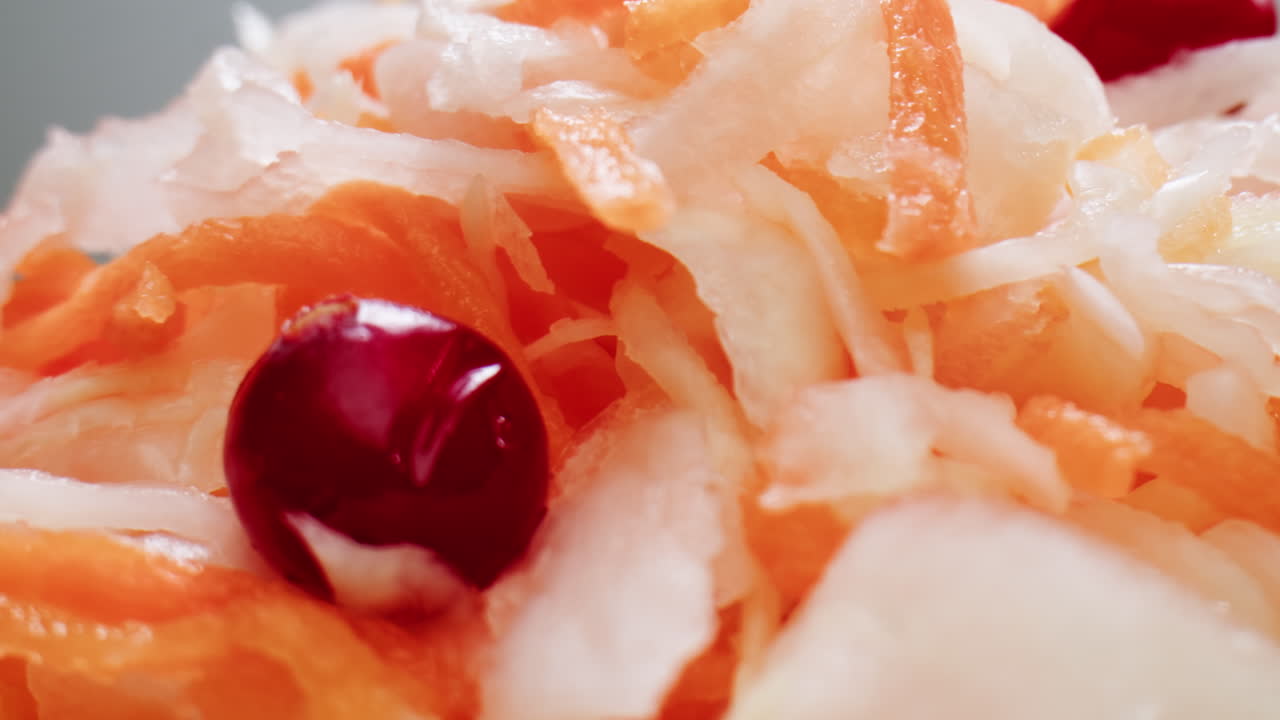 소크라우트 (sauerkraut) 는 소금 잔디를 보존하는 다양한 종류의 콩입니다. 나무 테이블에 당근과 러드 콩과 함께 소금 콩을 넣은 가정용 소크라우드. 고품질의 4k 영상.