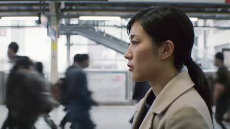 woman waiting at a train station in japan