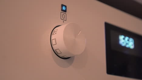 Oven-control-knob-pops-out-of-panel-and-oven-setting-adjusted,-closeup