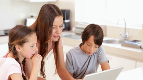 madre usando la computadora portátil con sus hijos